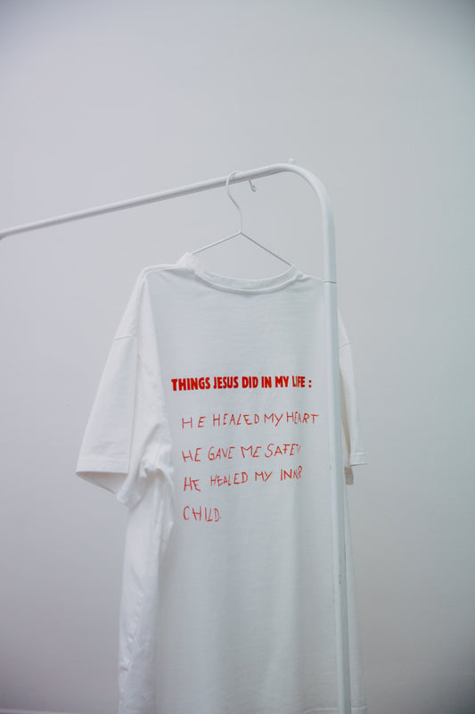 
"Ein kreatives, selbstgestaltetes T-Shirt mit handgeschriebenen Botschaften , die den Glauben und persönliche Erfahrungen ausdrücken. Das T-Shirt ist mit einem Textilmarker beschriftet und zeigt inspirierende Zitate, die zur Gemeinschaft und zur Reflexion über den Glauben anregen."